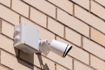 videcam mounted on a brick wall of a house on a summer day