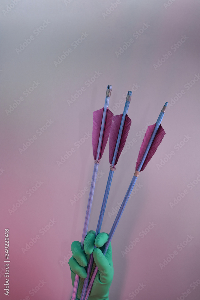 Poster Beautiful hand holding old green arrows in the color light. Beautiful old arrow minimal in neon light. Minimalism retro style concept. Background pattern for design..