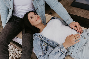 Fototapeta premium Young beautiful pregnant woman sitting on windowsill at home