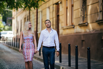 walking down the street together. Happy young man and smiling woman walking through the streets of Old Town,