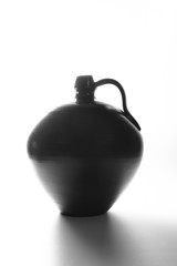 A black clay vase with white background