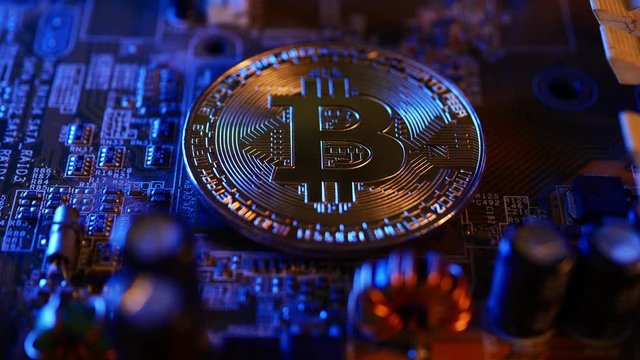 Golden coins with bitcoin symbol on a main board computer.	