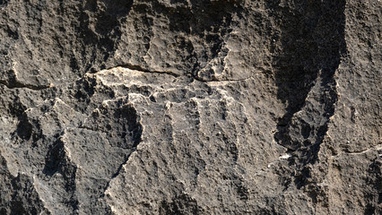 large texture of a large black stone. contrasting light on the stone