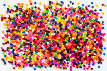 Multicolored plastic beads texture background. Top view