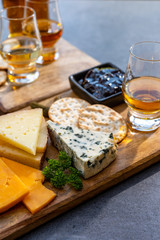 Whiskey and cheese pairing, tasting whisky glasses and plate with sliced cheeses