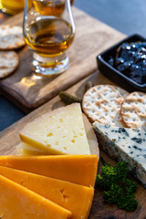 Whiskey and cheese pairing, tasting whisky glasses and plate with sliced cheeses