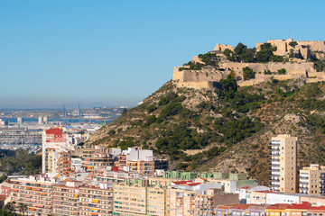Fototapeta na wymiar Panoramic view of Alicante, Valencian Community, Spain. In the foreground the Castle of Santa Barbara, the Postiguet beach and the port in the background with the city on its shore 