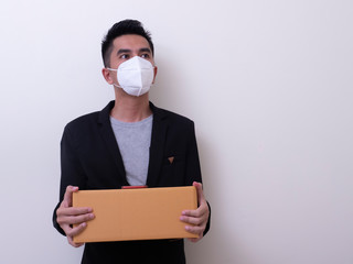 Happy delivery service employee in medical face mask carry cardboard box in hand