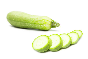 Fresh organic green zucchini with slices isolated on a white background.