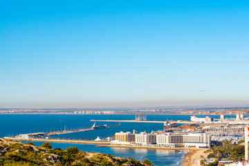 Fototapeta na wymiar Panoramic view of Alicante, Valencian Community, Spain. In the foreground the Castle of Santa Barbara, the Postiguet beach and the port in the background with the city on its shore 