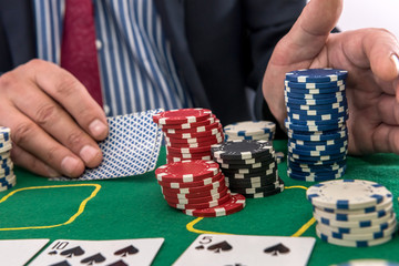 Naklejka premium man play in casino with playing cards and chips at green table