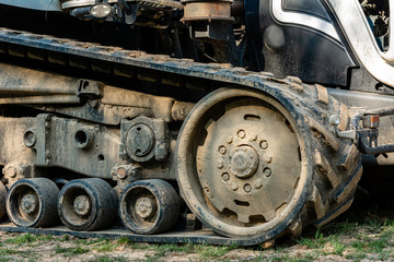 Fototapeta na wymiar Tractor caterpillar on an agricultural field close up. A modern new tracked tractor is very close.