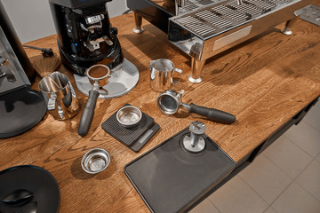 coffee grinder, coffee horn, tamper, grain, bowl, pitcher, holder, chalda on a wooden table. Utensils for a coffee shop. Coffee shop. Coffee tools