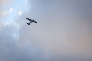 Small plane flying on the backgorund of clouds. Photo taken in cloudy day, Europe, Latvia.