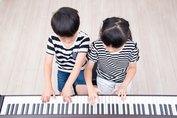 ピアノの練習をする姉弟