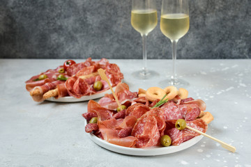 italian  prosciutto, salami, bresaola olives tomatoes and grissini bread sticks. Aperitif in Italy in Florence, Rome, aperitif in Milan. Serving appetizers for an aperitif, lunch, dinner and holiday.