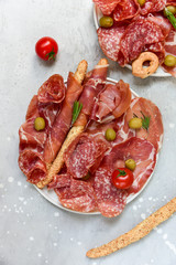 Traditional Italian appetizers ( antipasti ) : salami, bresaola, prosciutto, olives and sticks of cereal bread. Aperitif in Italy in Florence, Rome, aperitif in Milan.  and sticks of cereal bread
