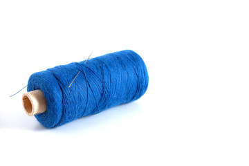 Blue thread with a needle on a white background. Suitable for advertising background. Sewing supplies