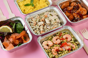 Healthy food restaurant dish delivery. Take away fitness meal banner. Different aluminium lunch box with risotto, chicken chickpeas and rice, salmon salad, hot chicken teriyaki, shrimp and green beans