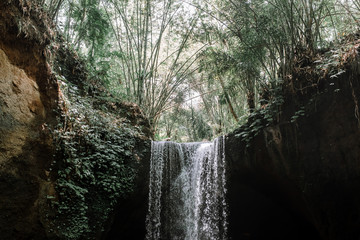 Amazing waterfall Suwat in Gianyar, Bali Indonesia, a stunning island. Jungle waterfall the best cascade in tropical rain forest with rock & turquoise blue pond.