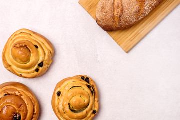 Freshly Baked Buns with Raisins and Cinnamon on Light Gray Background Top view Sweet Homemade...