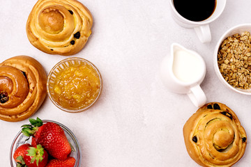 Tasty Breakfast Freshly Baked Buns with Raisins and Cinnamon Cup of Black Coffee Cream Ripe Strawberry and Orange Jam in Glass Bowl Top View Copy Space Frame Muesli
