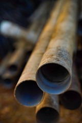 Old PVC water pipes with dust stacked in farm.