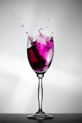 Ice falling into a glass and splash out the water.