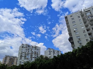 A view at a detail of a modern white apartment building, with blue sky background