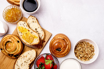Tasty Breakfast Freshly Baked Buns with Raisins and Cinnamon Fresh Homemade Bread Cup of Black Coffee Cream Ripe Strawberry and Orange Jam in Glass Bowl Top View Copy Space Frame Muesli