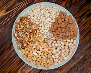 Plate with mixed nuts. Walnut, pistachios, almonds, cashews. Top view