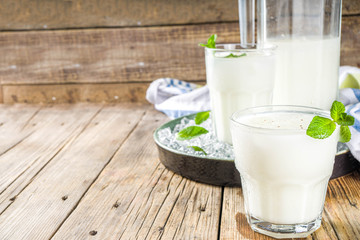 Cold Indian drink Lassi, iced coconut Lassi drink with mint leaf, wooden background copy space