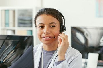 Portrait of African young woman in headphone sitting in front of computer she working in an ambulance © AnnaStills