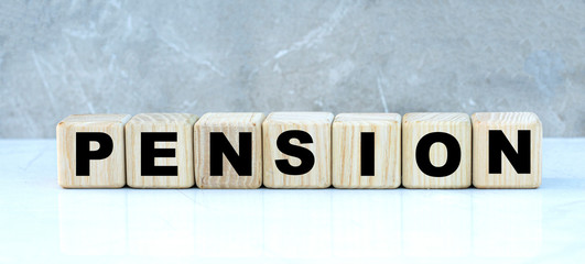 PENSION , the word on the cubes on a gray marble background. Business concept
