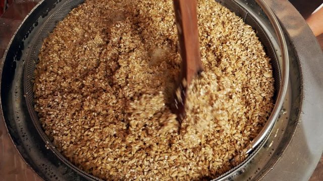 malt wort is stirred with a spoon while brewing homemade beer