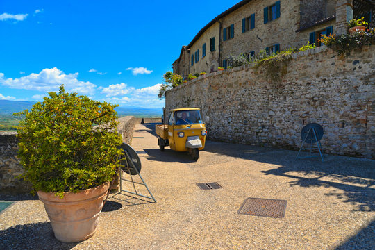 Vintage Ape car in old historic alley in the medieval village of Anghiari near city of Arezzo in Tuscany, Italy