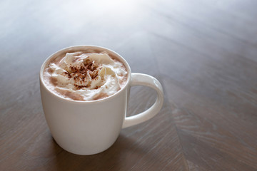 Hot chocolate cocoa with whipped cream on wooden background