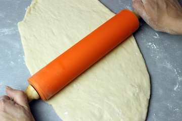 Dough circle with a rolling pin on the table
