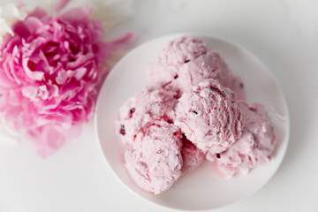 Balls of berry ice cream on a plate on a white background