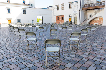 Social distancing during Covid or Coronavirus crisis, chairs keeping distance during a show, concert or exhibition, theater or cinema 