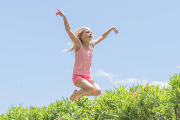 Happy crazy kid jumping on a trampoline, Summertime fun