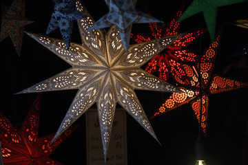 Beautiful paper lanterns in shape of stars as Christmas decorative elements lightning