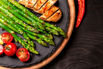 Balanced lunch Healthy grilled chicken, grilled avocado and asparagus salad with seeds. Food recipe background. Close up