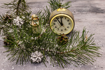 Few minutes to midnight. New Year concept. Alarm clock, pine branch, Christmas decorations