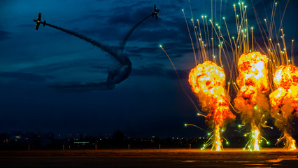 Bucharest, Romania - June 20, 2015 Yak 52 general aviation aerobatic airplane twilight pyrotechnic at airshow. Formation break simulation of world war 2 ground attack, fire, flames and explosion - obrazy, fototapety, plakaty