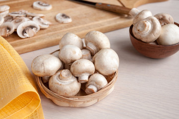 Still life: basket with mushrooms, cutting Board with slices of mushrooms on the table