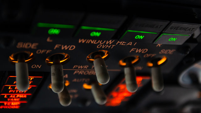 Detailed view of the window heat set of switches in the overhead panel of a large airliner cockpit . Selective focus with beautiful details of modern commercial jet aircraft flight deck