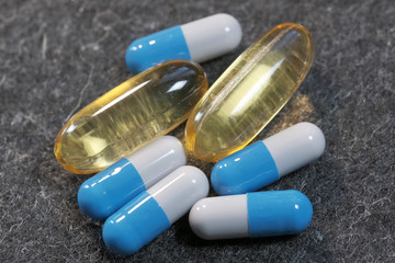 Yellow and blue gelatin soluble capsules with vitamin