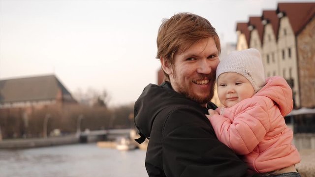 Young dad hugs little girl in the street