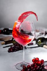 Splash Red wine. Bottle and glass of red wine and ripe grapes. Design with space for your text. Vintage style